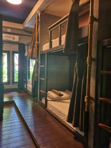 two bunk beds in a room with wooden floors at Aha Lanta Cozy Hostel in Ko Lanta