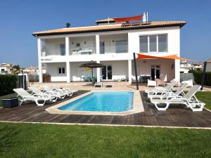 a villa with a swimming pool and lounge chairs at Villa Bellevue in Albufeira