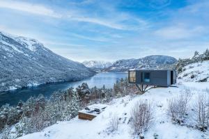 a cabin in the snow next to a river at Sogndal Fjordpanorama - The view in Sogndal