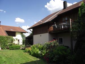 a house with a balcony and a yard with flowers at Haus Rottauenblick in Bad Birnbach