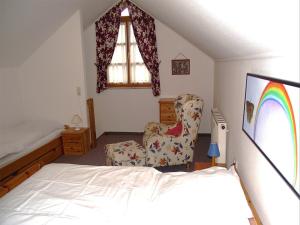 ein Schlafzimmer mit einem Bett und einem Stuhl in der Unterkunft Haus Rottauenblick in Bad Birnbach