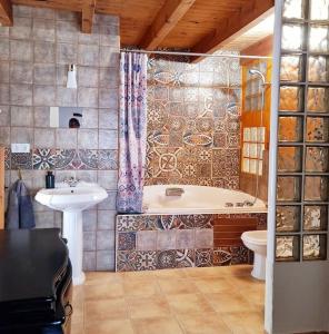 a bathroom with a tub and a toilet and a sink at Acogedora casa del siglo XIX 