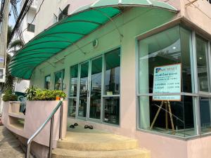a store with a green awning and a sign in the window at My Space 77 in Ban Khlong Khwang Klang +6 photos