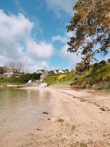 a sandy beach next to a body of water at MAISON ST CHRISTOPHE in Lézardrieux