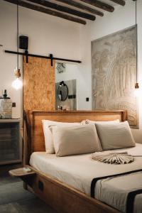 a bedroom with a large bed with a wooden headboard at BaraBara Eat&Sleep - Eco Boutique Hotel in Paje