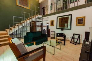 a living room with a green couch and a staircase at Résidence Decamaret Warang in Ouoran