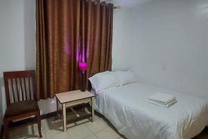 a bedroom with a bed and a table with a lamp at 2 bedroom Apt 20 min to JKIA Airport,SGR Train St. in Athi River