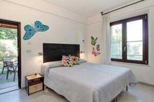 ein Schlafzimmer mit einem Bett mit Schmetterlingen an der Wand in der Unterkunft Artemisia negli ulivi b&b in Magliano in Toscana