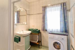 ein Badezimmer mit einem Waschbecken und einer Waschmaschine in der Unterkunft Ferienwohnung Stiegelbauer Zirbe in Gleinstätten