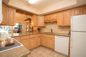a kitchen with wooden cabinets and a white refrigerator at Shady Palms in Ponte Vedra Beach