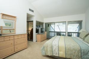 a bedroom with a bed and a dresser and a television at Shady Palms in Ponte Vedra Beach