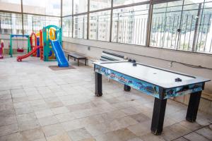 um quarto com uma mesa de pingue-pongue e um parque infantil em Lisboa Hotel em Poços de Caldas