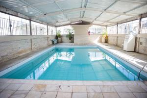 a swimming pool in a building with a ceiling at Lisboa Hotel in Poços de Caldas