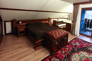 1 dormitorio con cama, mesa y alfombra en Vila Etnica, en Trebujeni