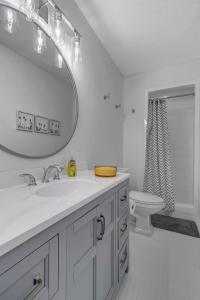 a bathroom with a sink and a mirror and a toilet at PV Clubhouse in Ponte Vedra Beach