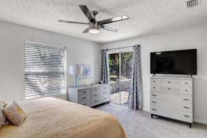 a bedroom with a bed and a flat screen tv at PV Clubhouse in Ponte Vedra Beach