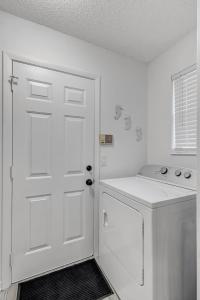 a white kitchen with a white door and a washer at PV Clubhouse in Ponte Vedra Beach