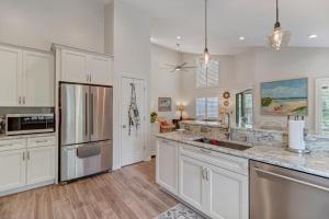 a kitchen with white cabinets and stainless steel appliances at Turtles Nest in Ponte Vedra Beach