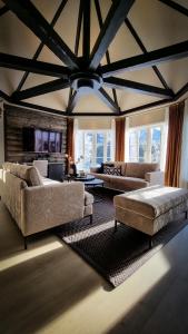 a large living room with couches and a ceiling at Sølvgarden Hotel in Rysstad