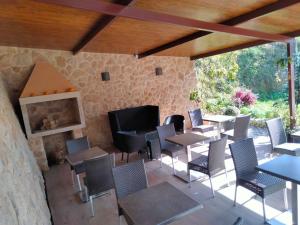 un patio con mesas y sillas y una chimenea en Hostal Nuevo Alonso en Bembribe