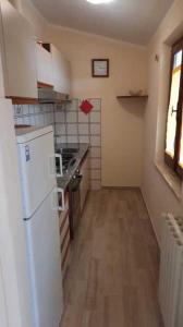 a small kitchen with a white refrigerator and a window at Fewo Sole e Azzurro in Capoliveri +2 photos