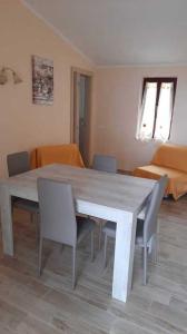 a dining table and chairs in a living room at Fewo Sole e Azzurro in Capoliveri