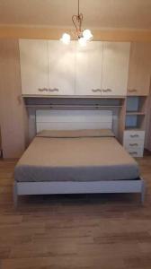 a bedroom with a bed with white cabinets at Fewo Sole e Azzurro in Capoliveri