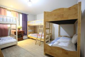 a room with three bunk beds and a desk at Pohang Youngildae Guesthouse in Pohang