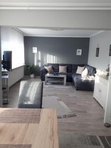uma sala de estar com um sofá e uma mesa em Ferienwohnung Hansen-Jöns em Friedrichstadt