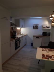 a kitchen with white appliances and a table in it at Ferienwohnung Hansen-Jöns in Friedrichstadt