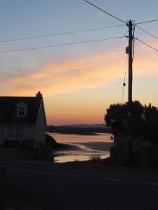 KincasslaghにあるVillage Way Apartmentsの日没時の海の景色を望む家
