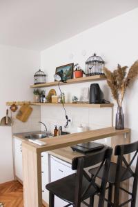 cocina con fregadero y barra con sillas en Bohome studio sa terasom - FREE PARKING en Vranje