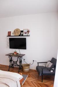 a living room with a tv and a table at Bohome studio sa terasom - FREE PARKING in Vranje