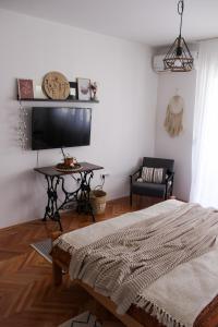 a living room with a bed and a table at Bohome studio sa terasom - FREE PARKING in Vranje