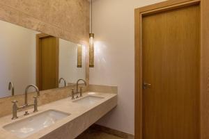 a bathroom with two sinks and a mirror at Ksar Char-Bagh Small Luxury Hotels in Marrakesh