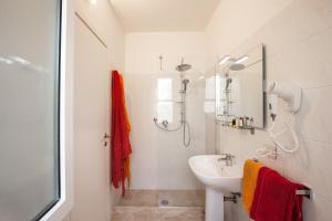 un bagno bianco con lavandino e doccia di Artemisia negli ulivi b&b a Magliano in Toscana Altre 53 foto