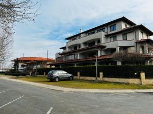a car parked in front of a large building at PannaRoza Apartman in Balatonlelle