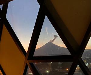 a view of a mountain through a window at Loft industrial vista a los volcanes in Cholula