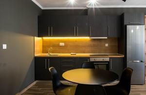 a kitchen with a table and some black cabinets at Stamatina's Luxury Apartments (Central 3rd floor) in Alexandroupoli
