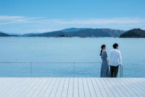 een man en vrouw die op een pier naar het water staan te kijken bij SETONITE in Tamano