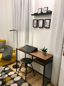 Cette chambre comprend un bureau, une chaise et un canapé. dans l'établissement Andrea Apartman Miskolc belvárosában, à Miskolc