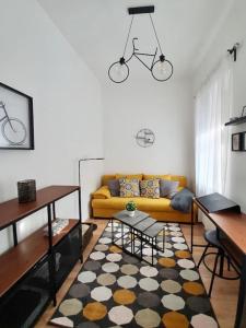 - un salon avec un canapé jaune et un tapis dans l'établissement Andrea Apartman Miskolc belvárosában, à Miskolc