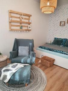 un salon avec une chaise et un lit dans l'établissement Andrea Apartman Miskolc belvárosában, à Miskolc 32 autres photos