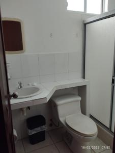 ein weißes Bad mit einem WC und einem Waschbecken in der Unterkunft HOSTERIA PUERTO BALBANERA in Tonsupa