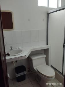 bagno bianco con servizi igienici e lavandino di HOSTERIA PUERTO BALBANERA a Tonsupa