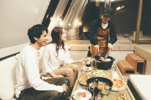 a group of people sitting around a table with food at SETONITE in Tamano