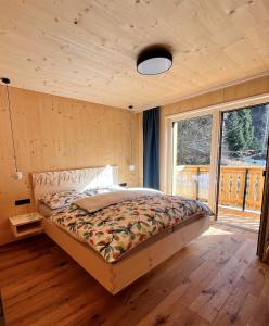 a bedroom with a bed and a large window at Bio Felderhof in Villa Ottone