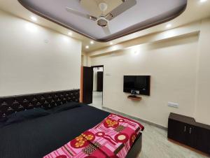 a bedroom with a bed and a flat screen tv at Modern 3BHK Apt for Big Groups & Family in Kasba in Kolkata
