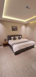 a bedroom with a large bed in a room at شقق ظلال النخيل in Al Khobar
