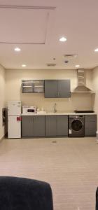 a kitchen with gray cabinets and appliances in a room at شقق ظلال النخيل in Al Khobar